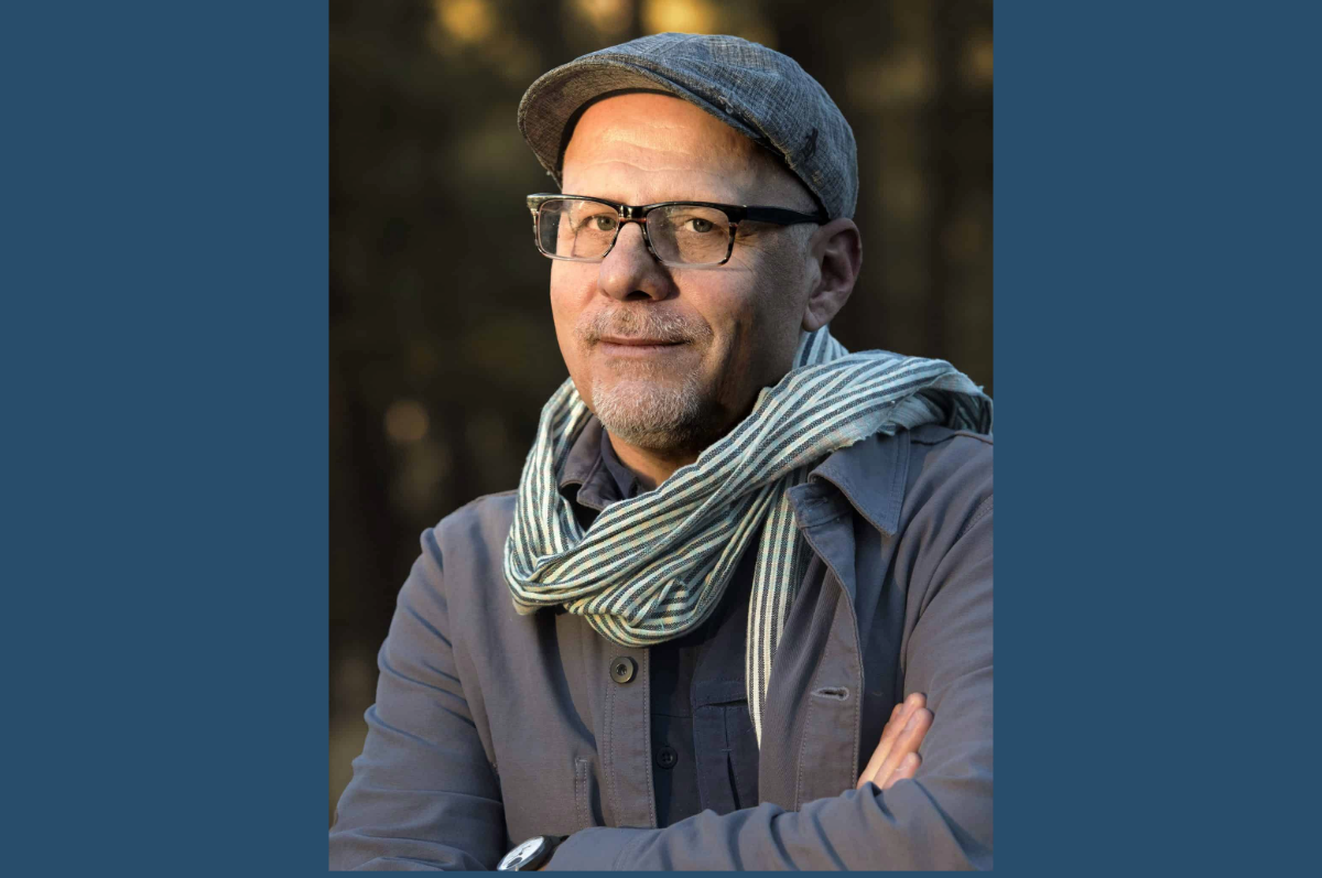 Portrait of man in cap and scarf with arms crossed
